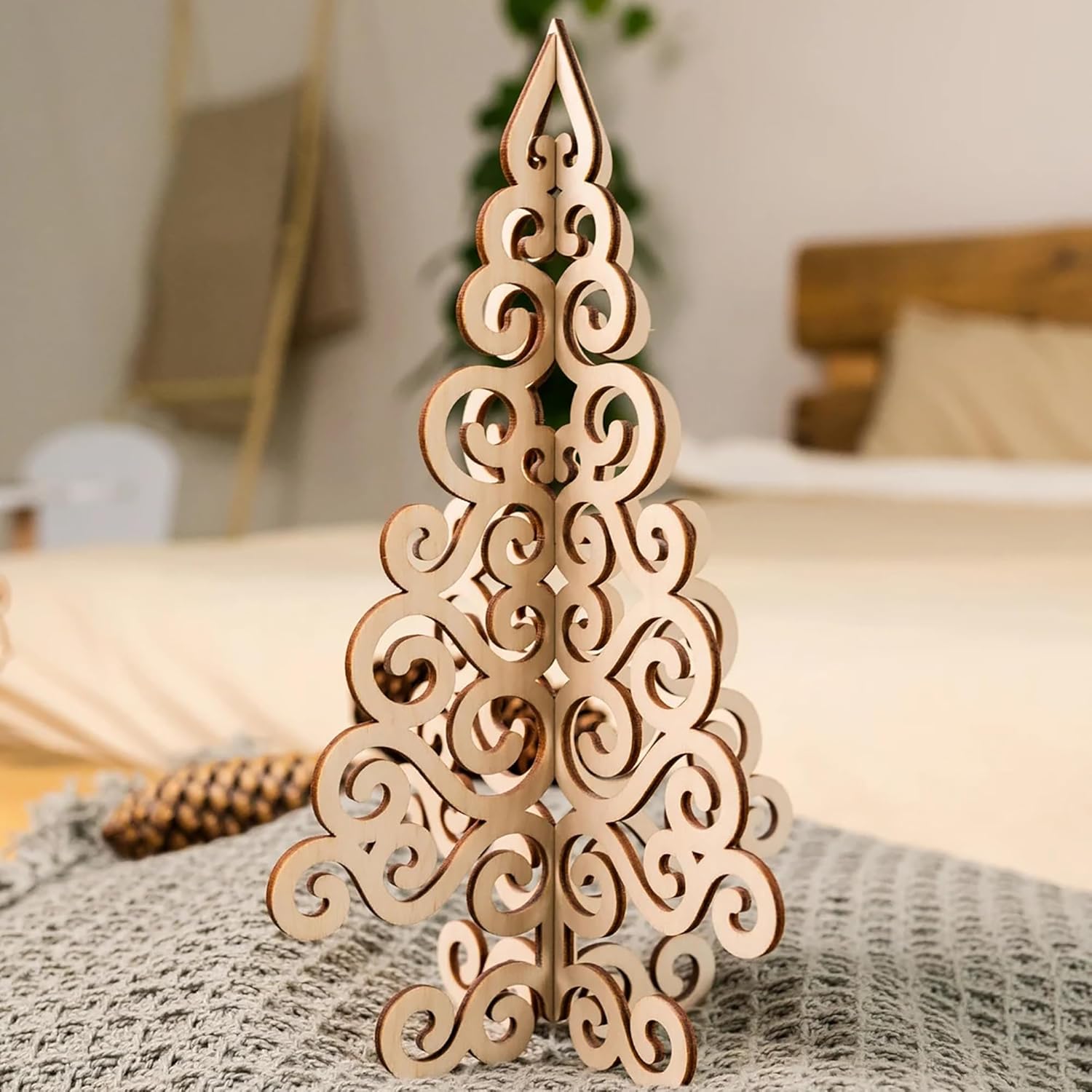 Decorative wooden Christmas tree on a bed with a blurred background