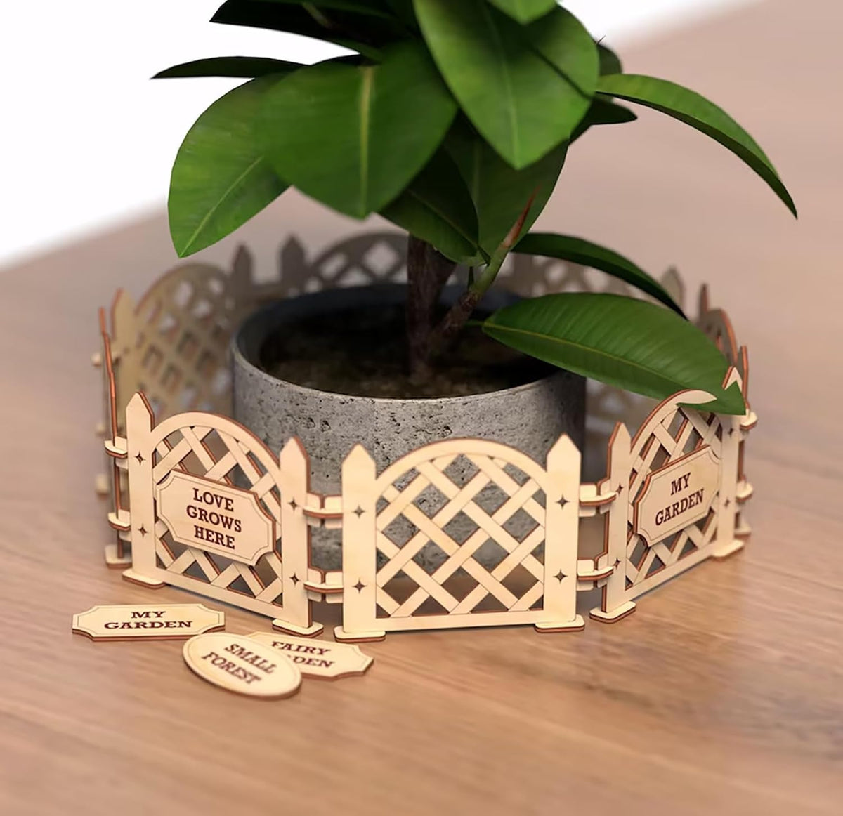 Wooden garden fence planter with a potted plant on a wooden surface