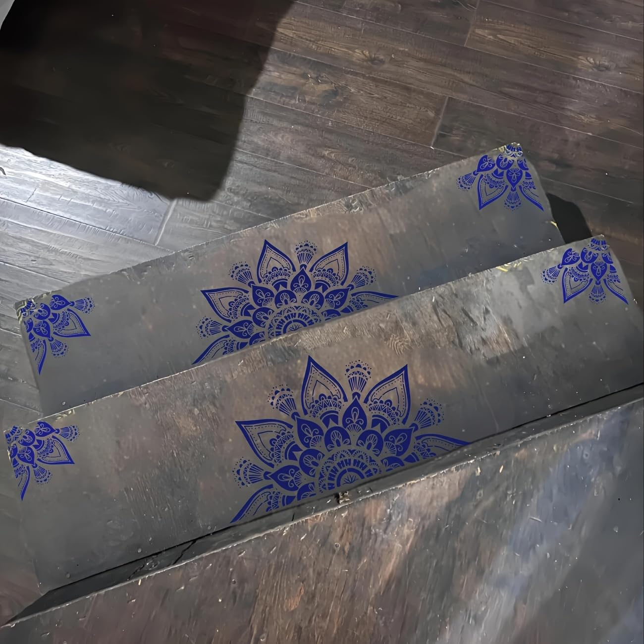 Metal sheets with blue floral patterns on a wooden surface