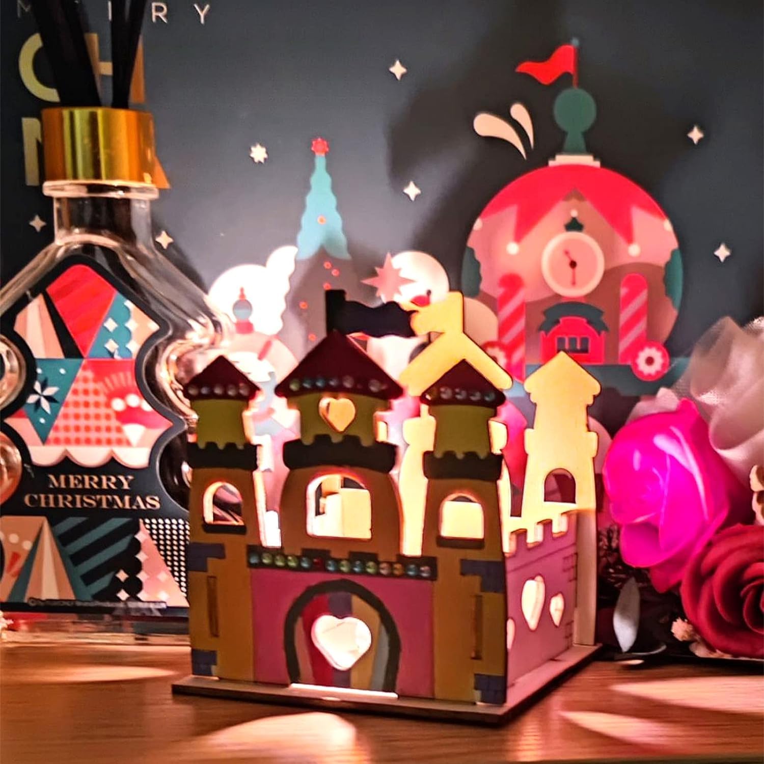 Decorative Christmas village scene with a bottle of alcohol in the background