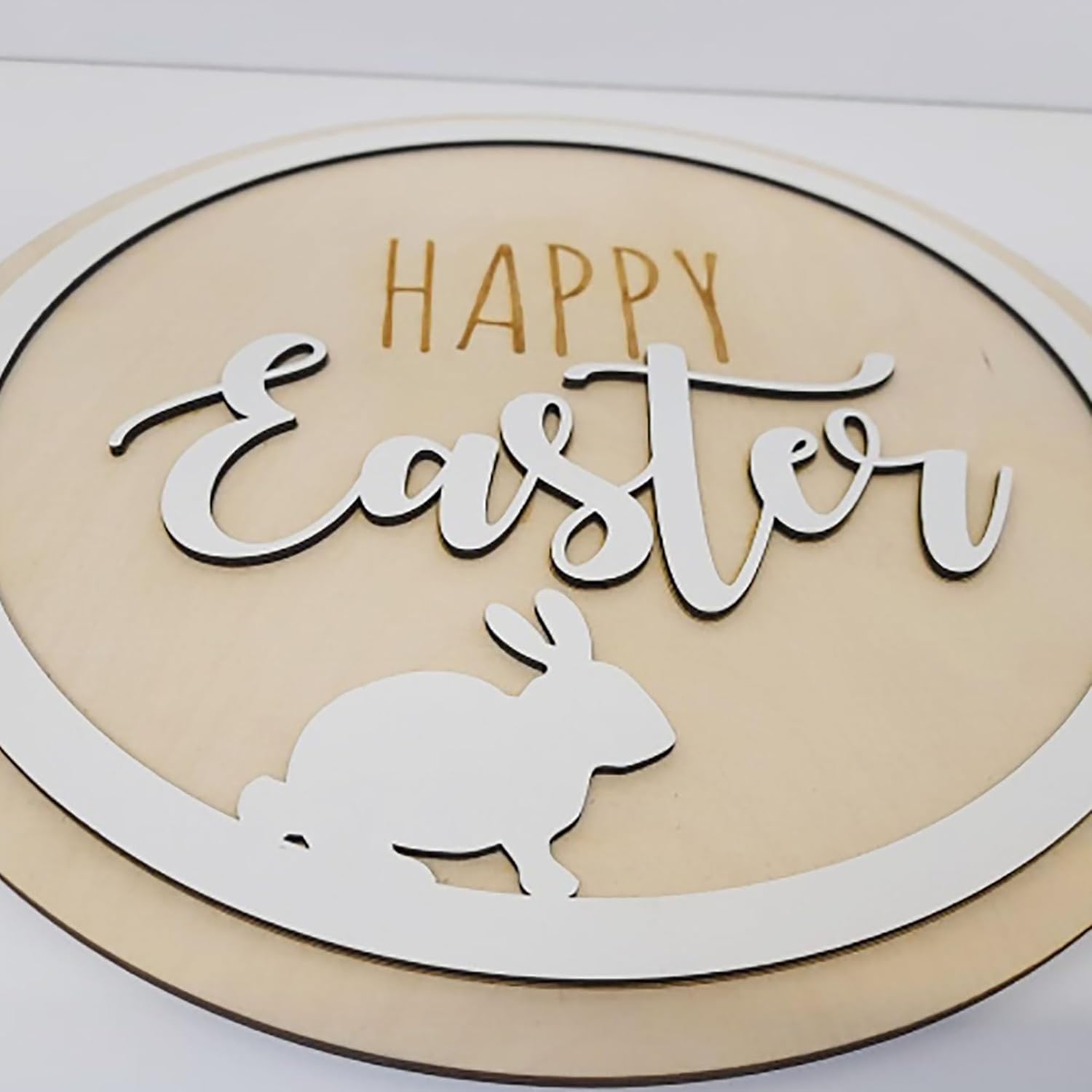 Decorative sign with 'Happy Easter' text and a rabbit silhouette on a beige background.