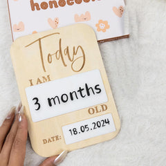 Baby milestone card with 'Today I am 3 months old' text on a soft surface