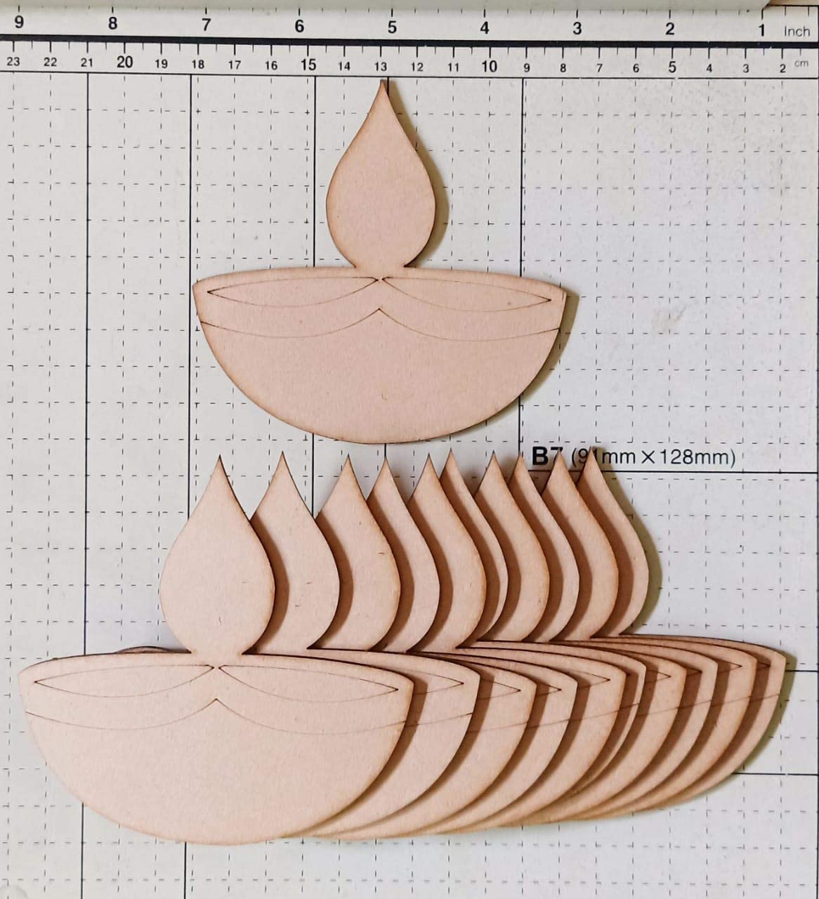 Wooden candle-shaped cutouts on a grid background