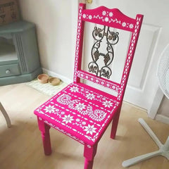 Pink chair with white floral patterns in a room setting