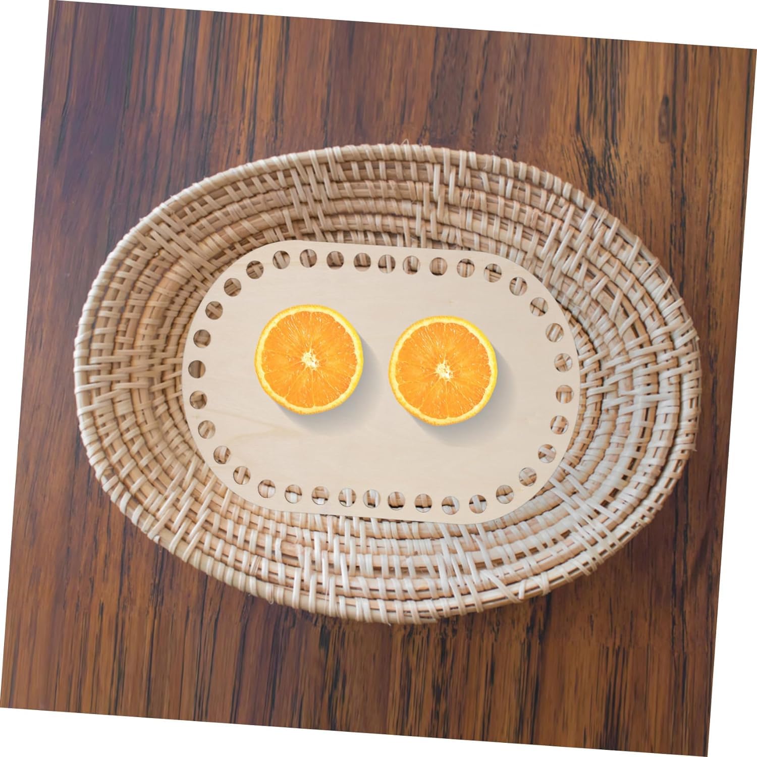 Two sliced oranges on a woven placemat with a wooden surface underneath
