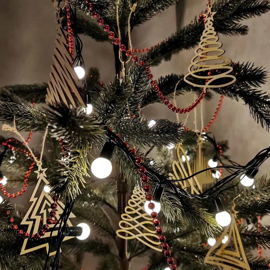 Decorative Christmas tree with lights, red beads, and geometric ornaments.