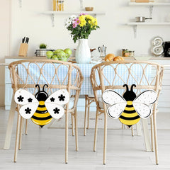 Two decorative bee-shaped chairs with a table and kitchen items in the background.