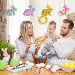 Family engaging in Easter activities with decorative bunnies and eggs on a wooden table.