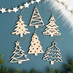 Wooden Christmas tree ornaments on a blue background with greenery around.
