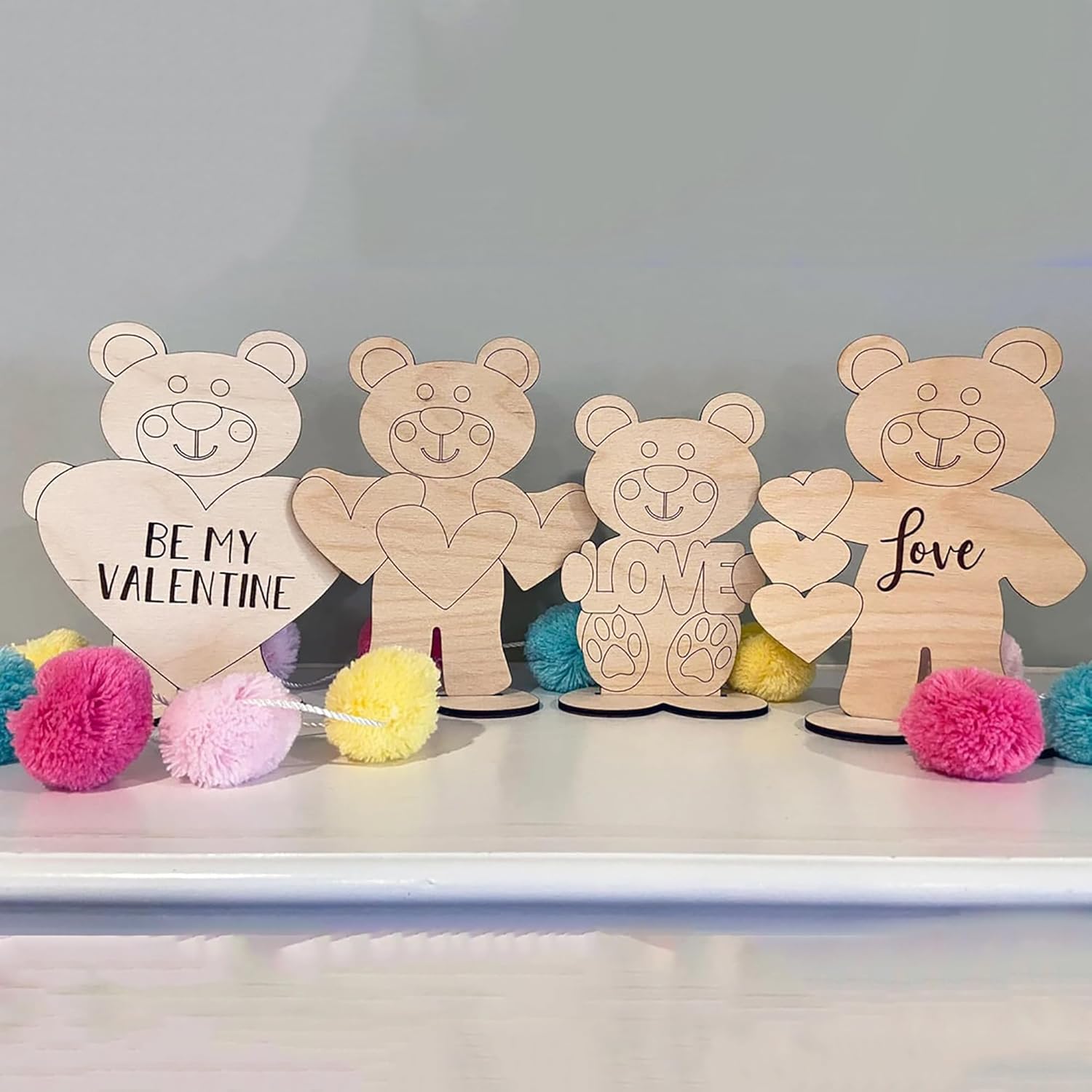 Wooden bear figurines with heart-shaped signs on a white surface