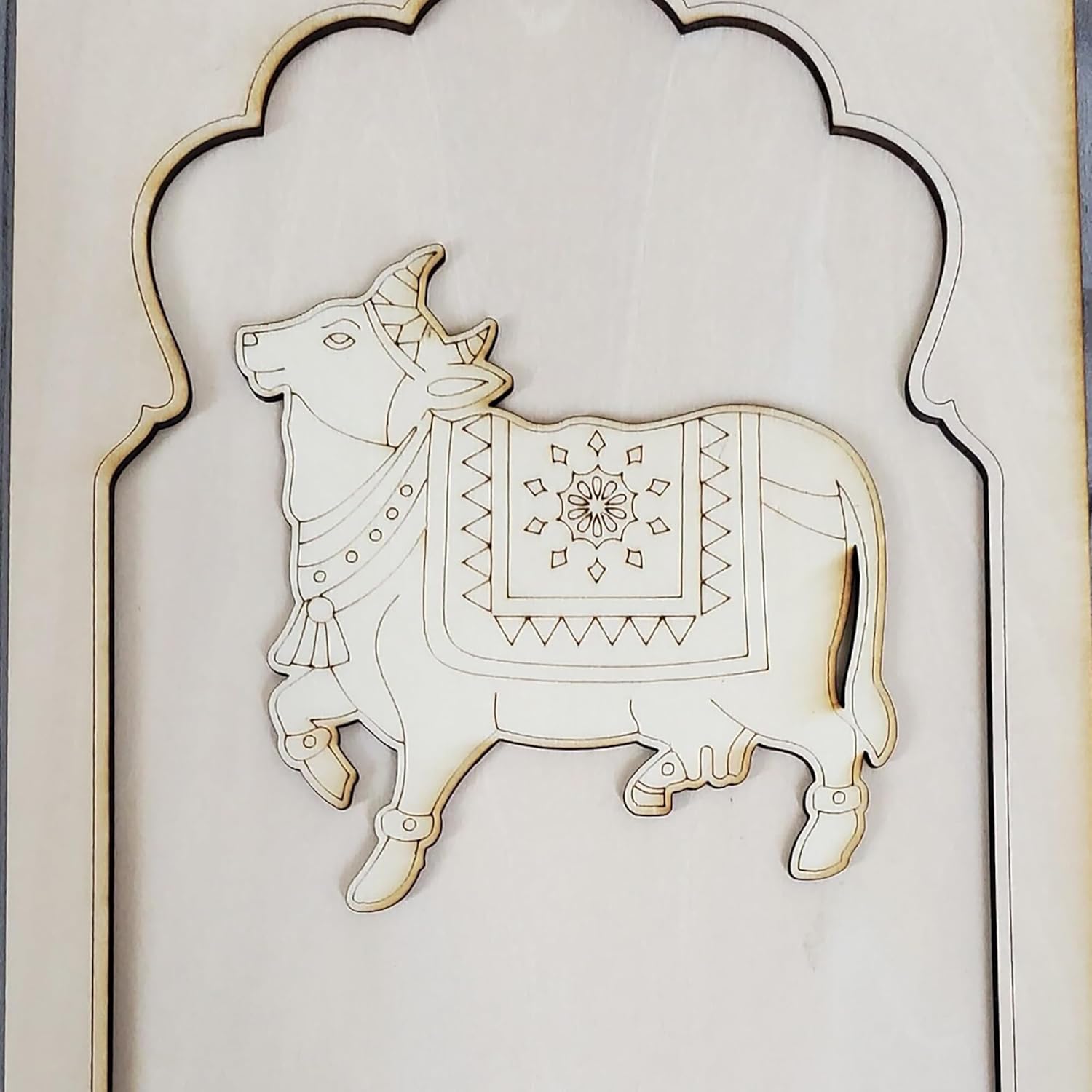 Decorative wall art of a bull with intricate patterns on a light background