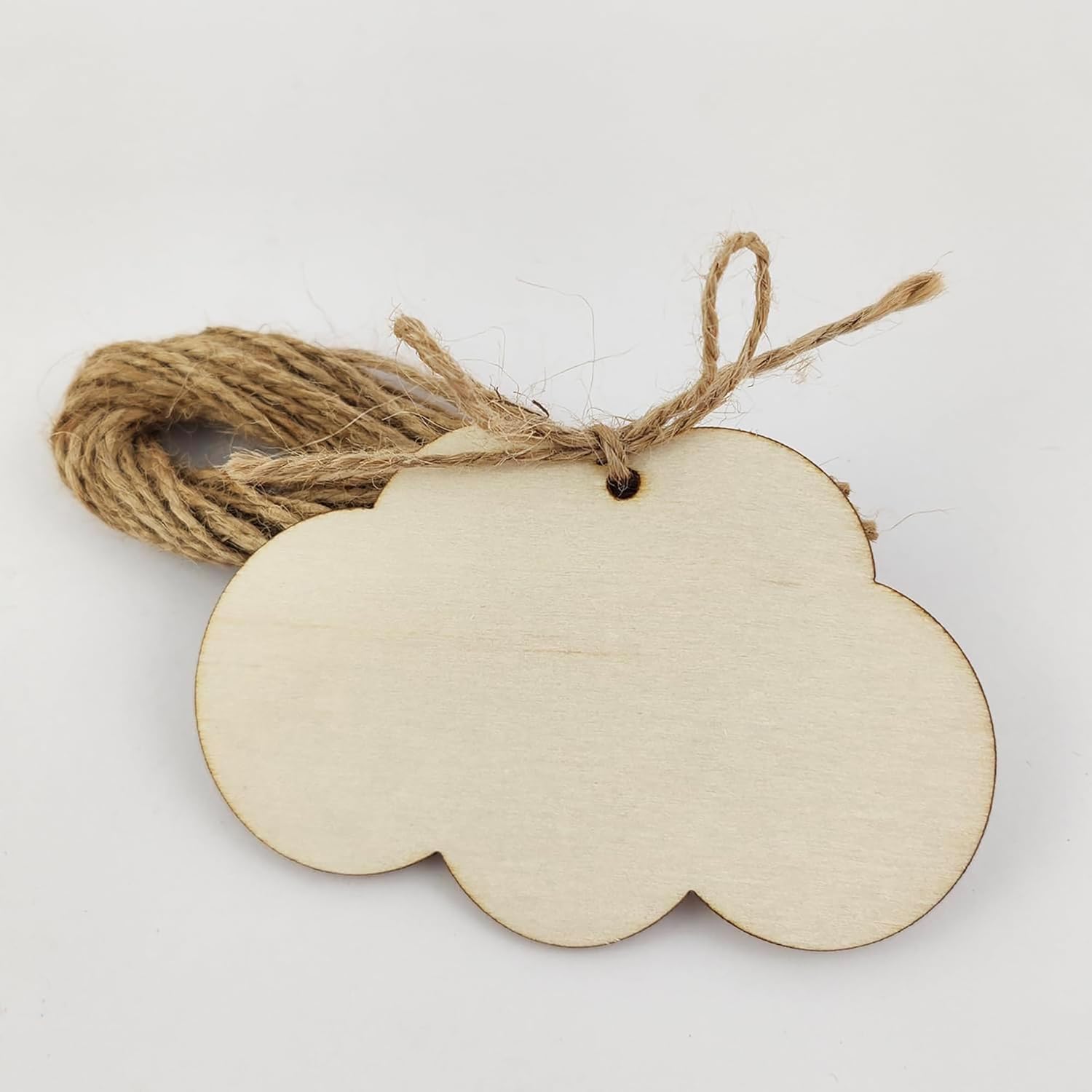 Wooden cloud-shaped tag with twine on a white background
