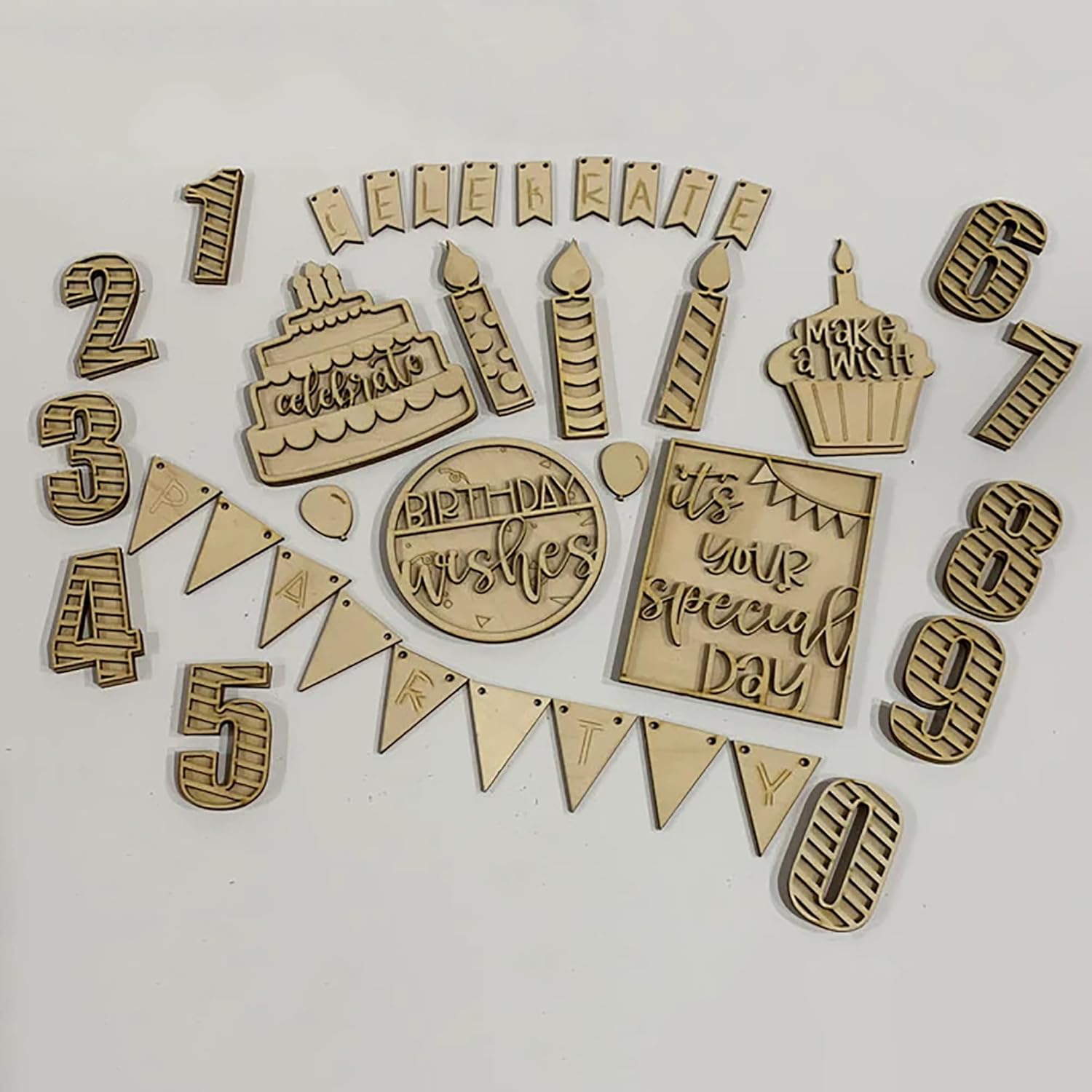 Collection of wooden birthday-themed decorations on a white background
