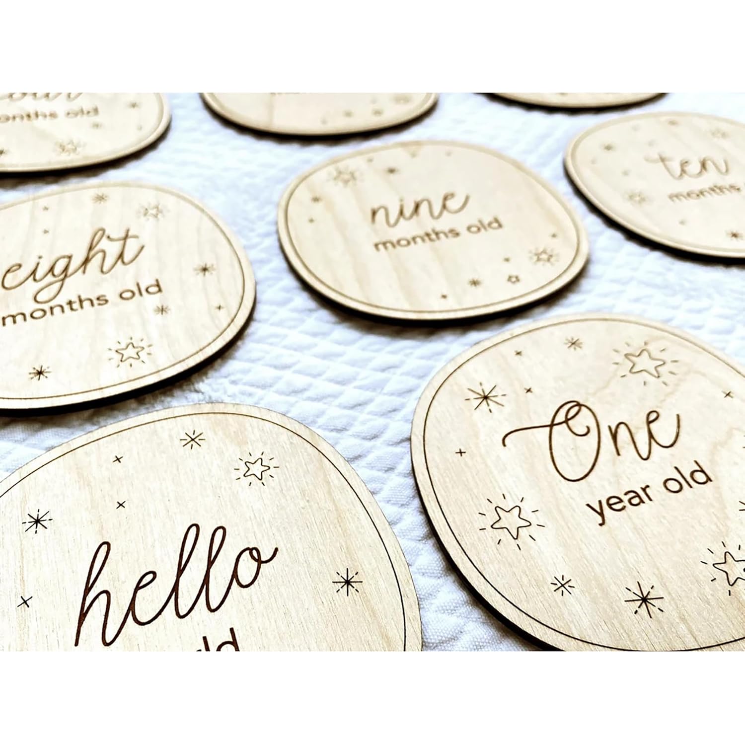 Wooden milestone discs with text for baby's age on a blue blanket