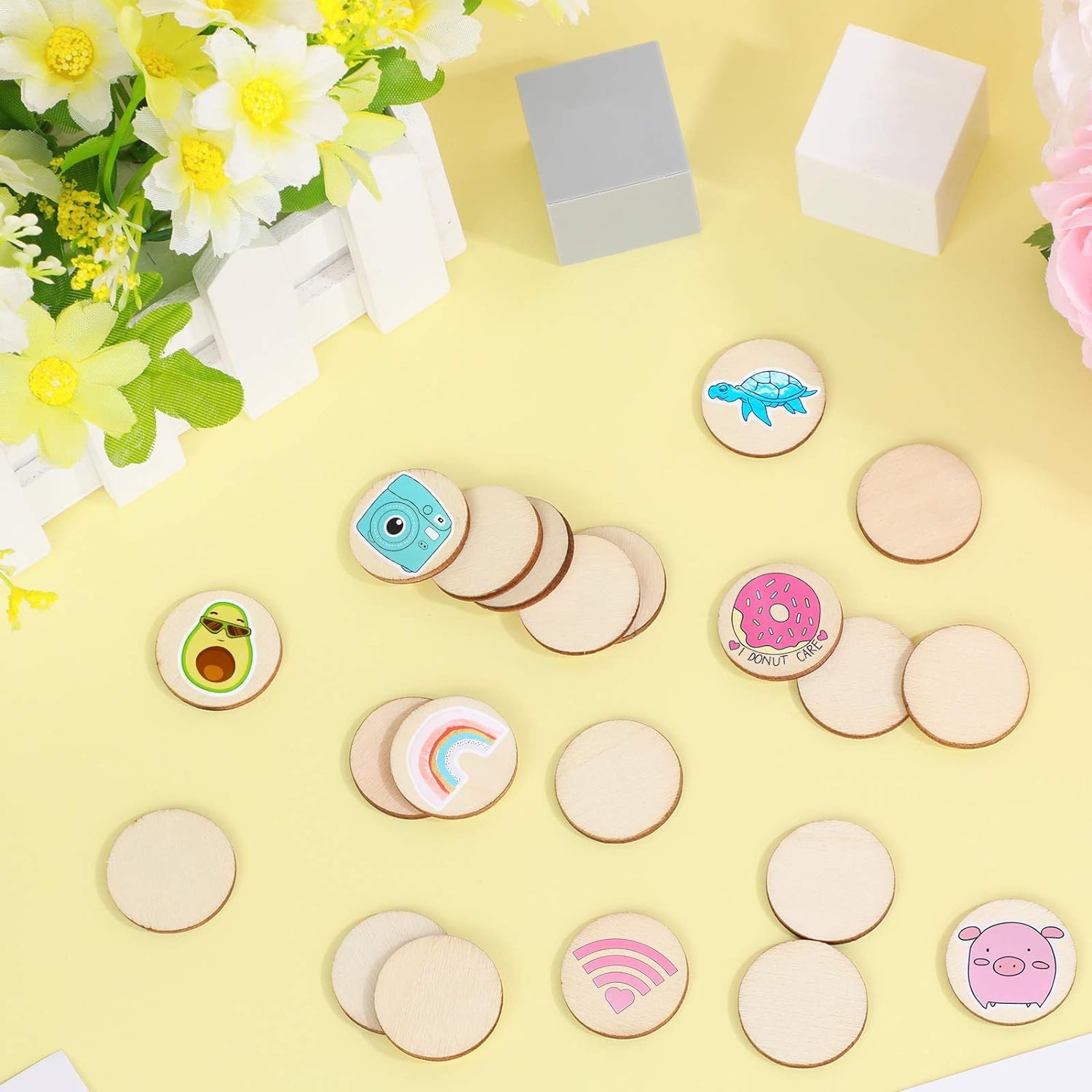 Wooden buttons with colorful designs on a yellow surface with flowers in the background