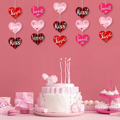 Valentine's Day-themed cake with decorative hearts and candles on a pink background.