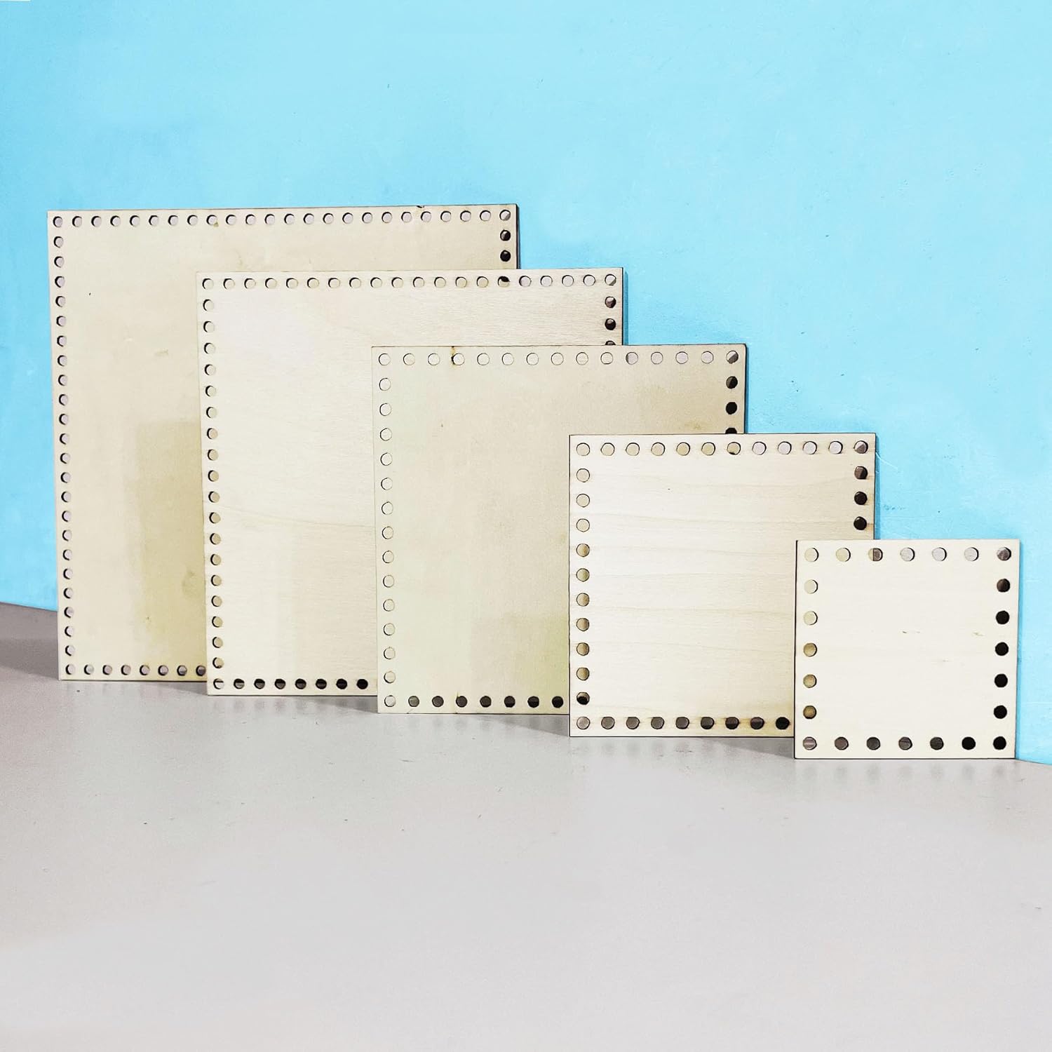 Set of square metal frames with holes on a light blue background