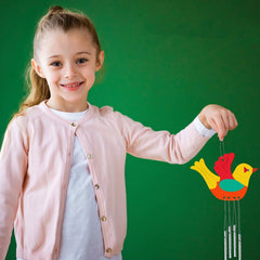 Young girl holding a colorful bird-shaped wind chime against a green background