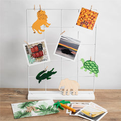 White magnetic board with various items including a lion, crocodile, and turtle illustration, and photos on a wooden surface.