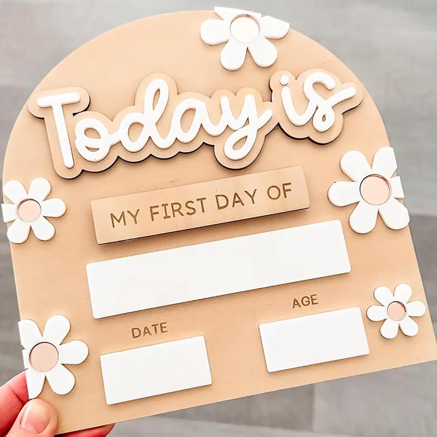 Children's first day of school sign with flowers and text on a beige background