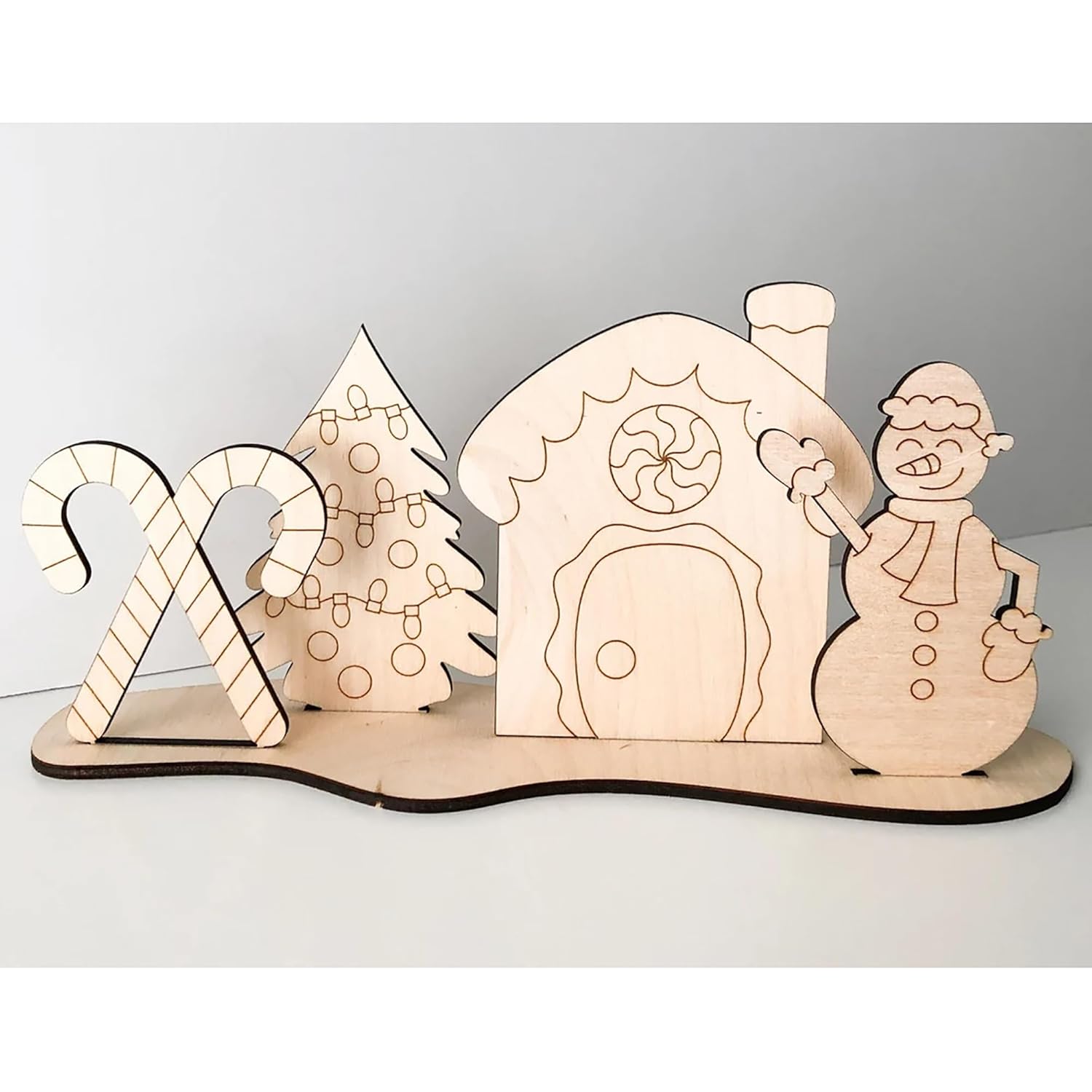 Wooden Christmas-themed set with house, tree, candy cane, and snowman on a white background