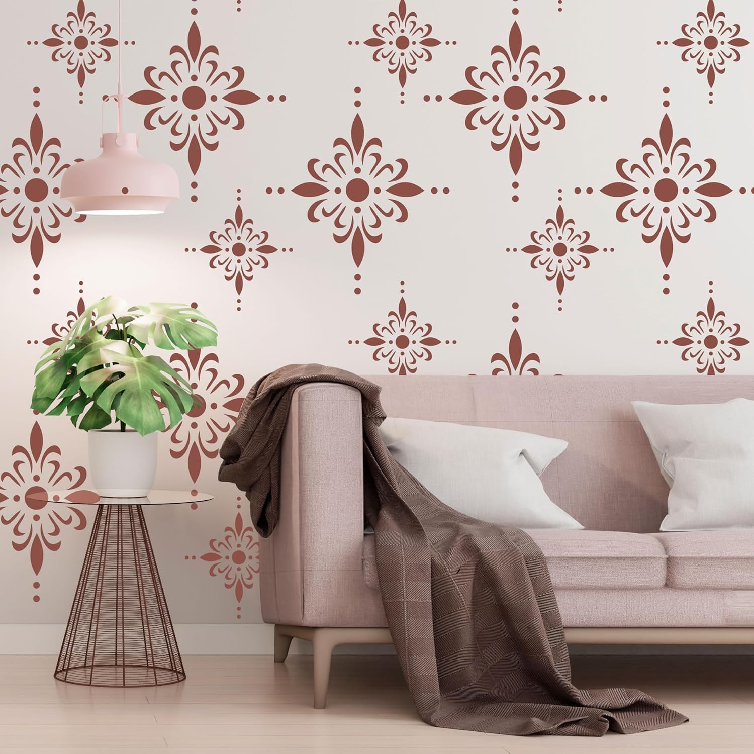 Living room with pink sofa, decorative wall patterns, and a plant.