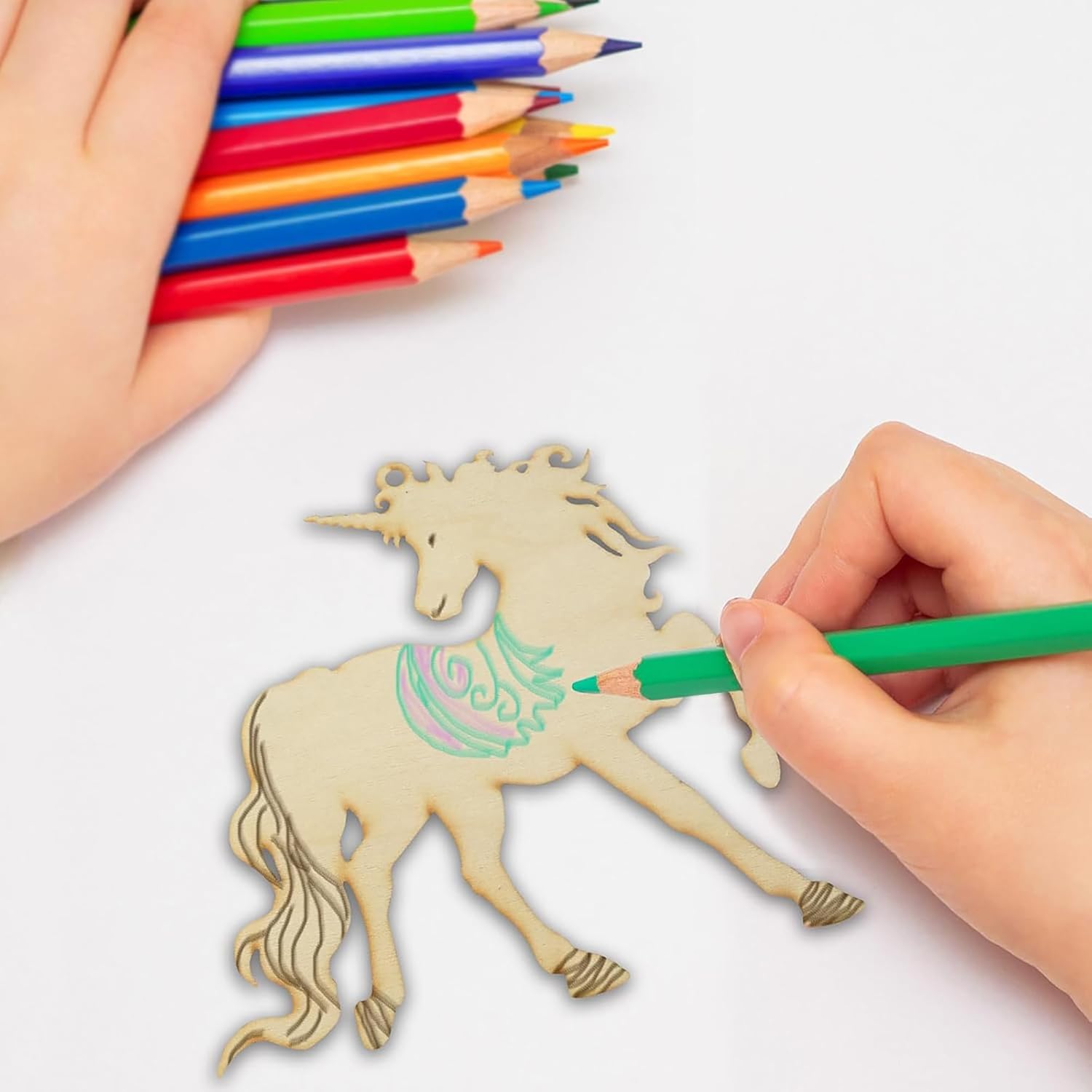 Hand coloring a wooden unicorn with colored pencils on a white background