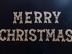 Decorative cutout letters spelling 'Merry Christmas' on a black background