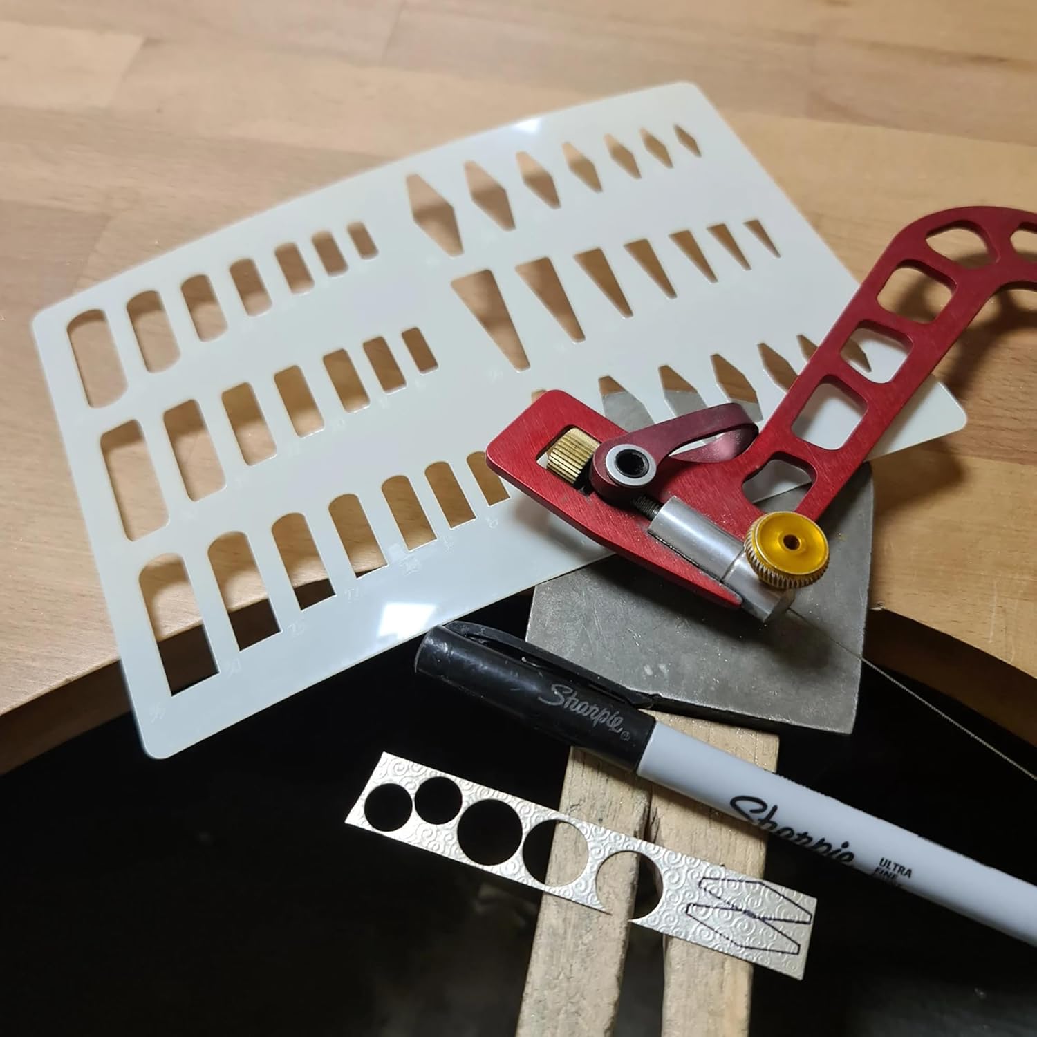 Set of tools including a red tool, white ruler, and Sharpie marker on a wooden surface.