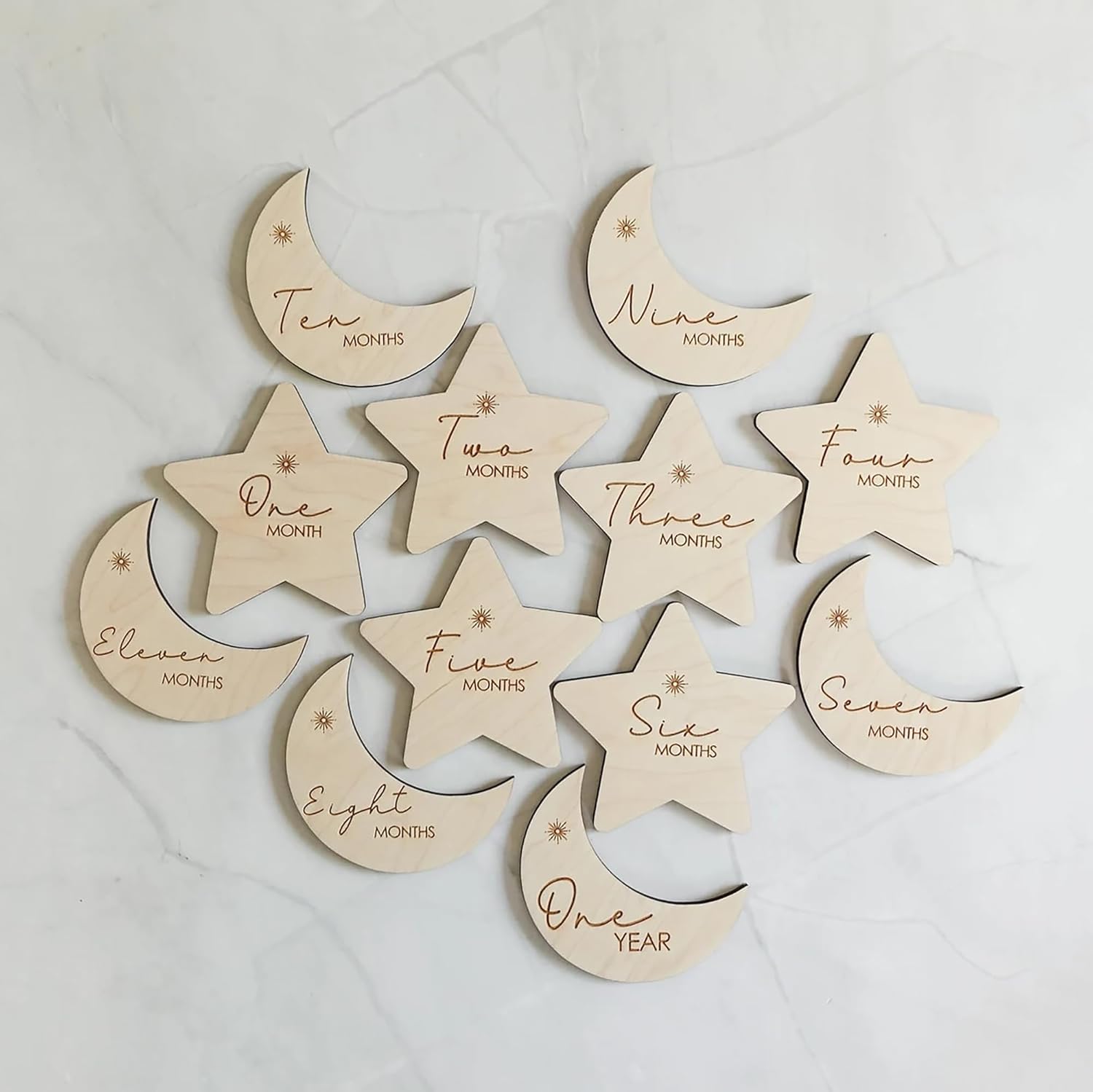 Wooden baby milestone markers with months engraved on a light background
