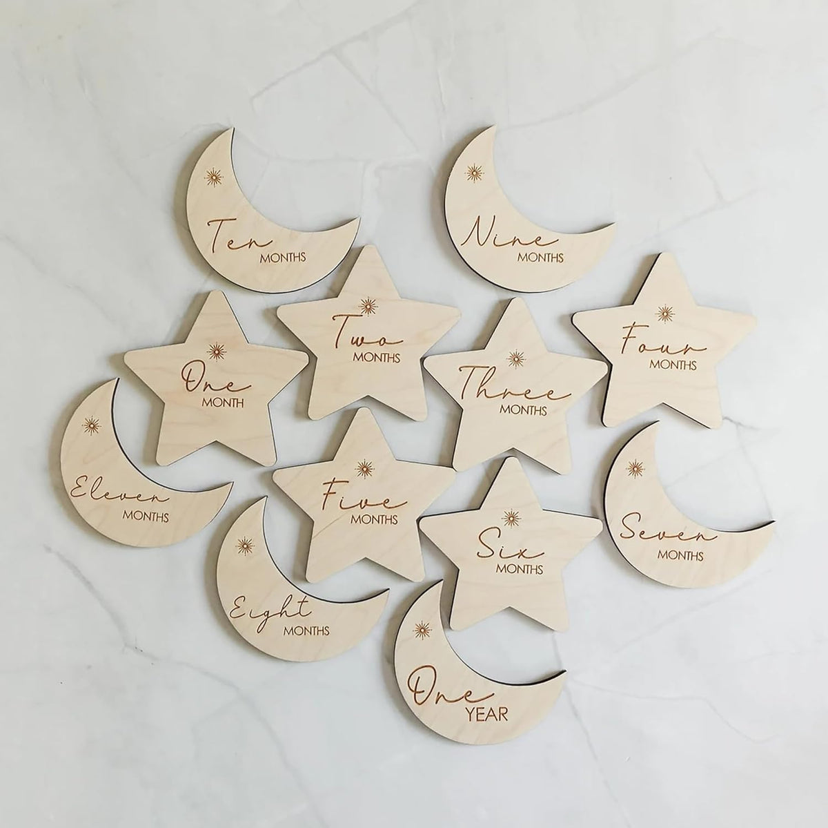Wooden baby milestone markers with months engraved on a light background