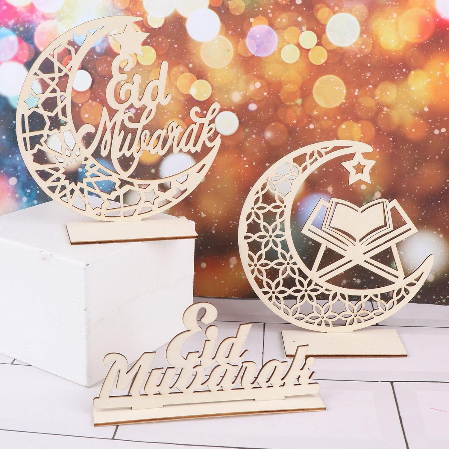 Decorative wooden signs with 'Eid Mubarak' on a blurred bokeh background
