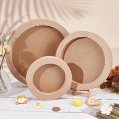 Three wooden bowls of different sizes on a light wooden surface with decorative items.