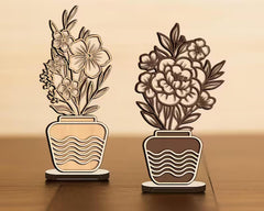 Two decorative plant lamps with floral designs on a wooden surface.