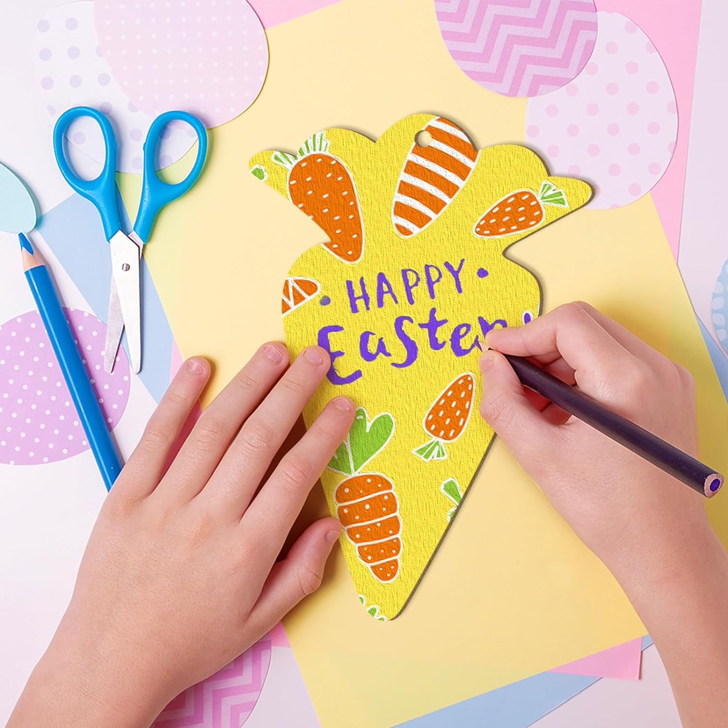 Child's hands coloring a yellow Easter card with blue scissors and markers on a colorful background