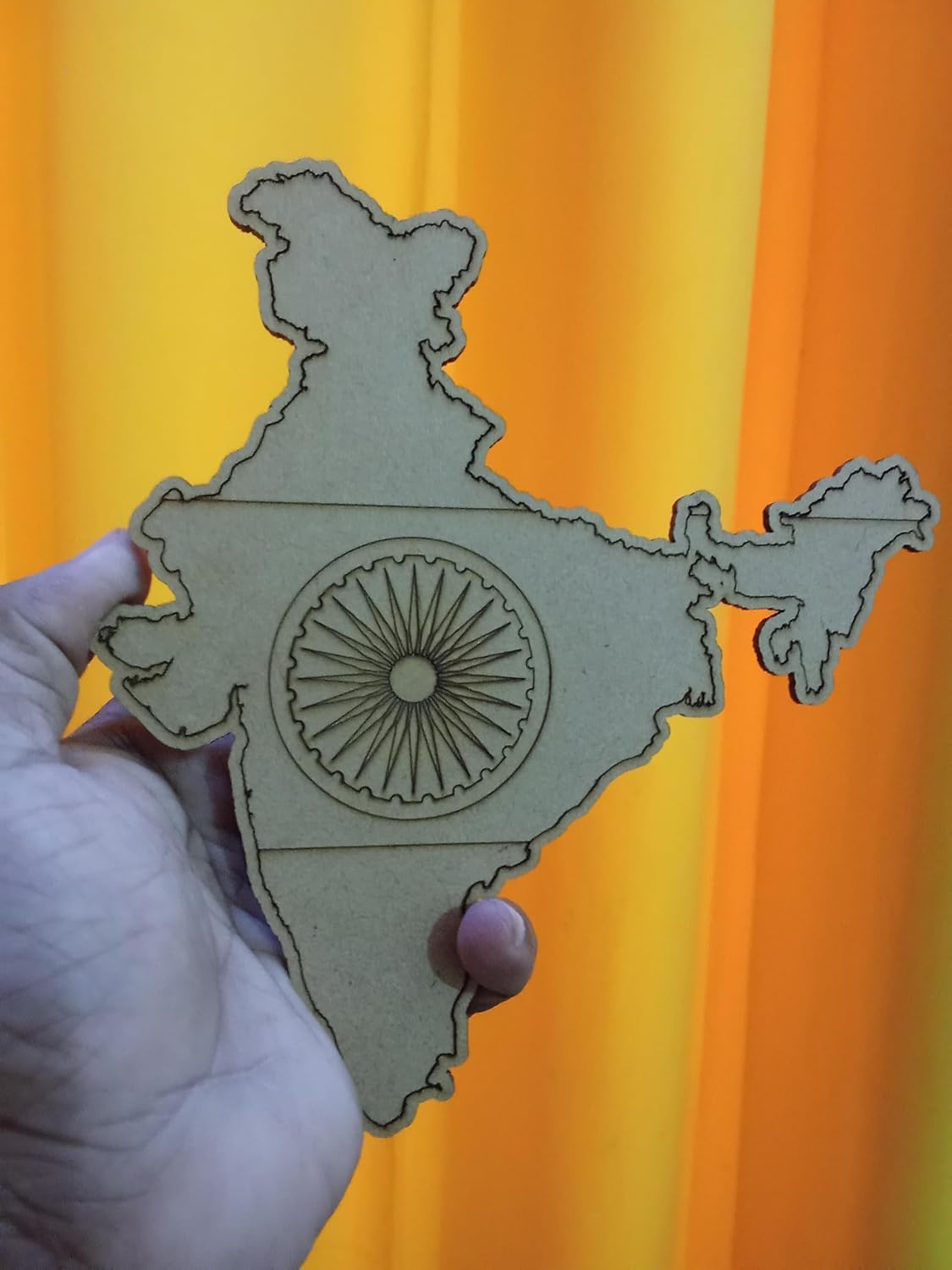 Map of India with a central emblem held against an orange background