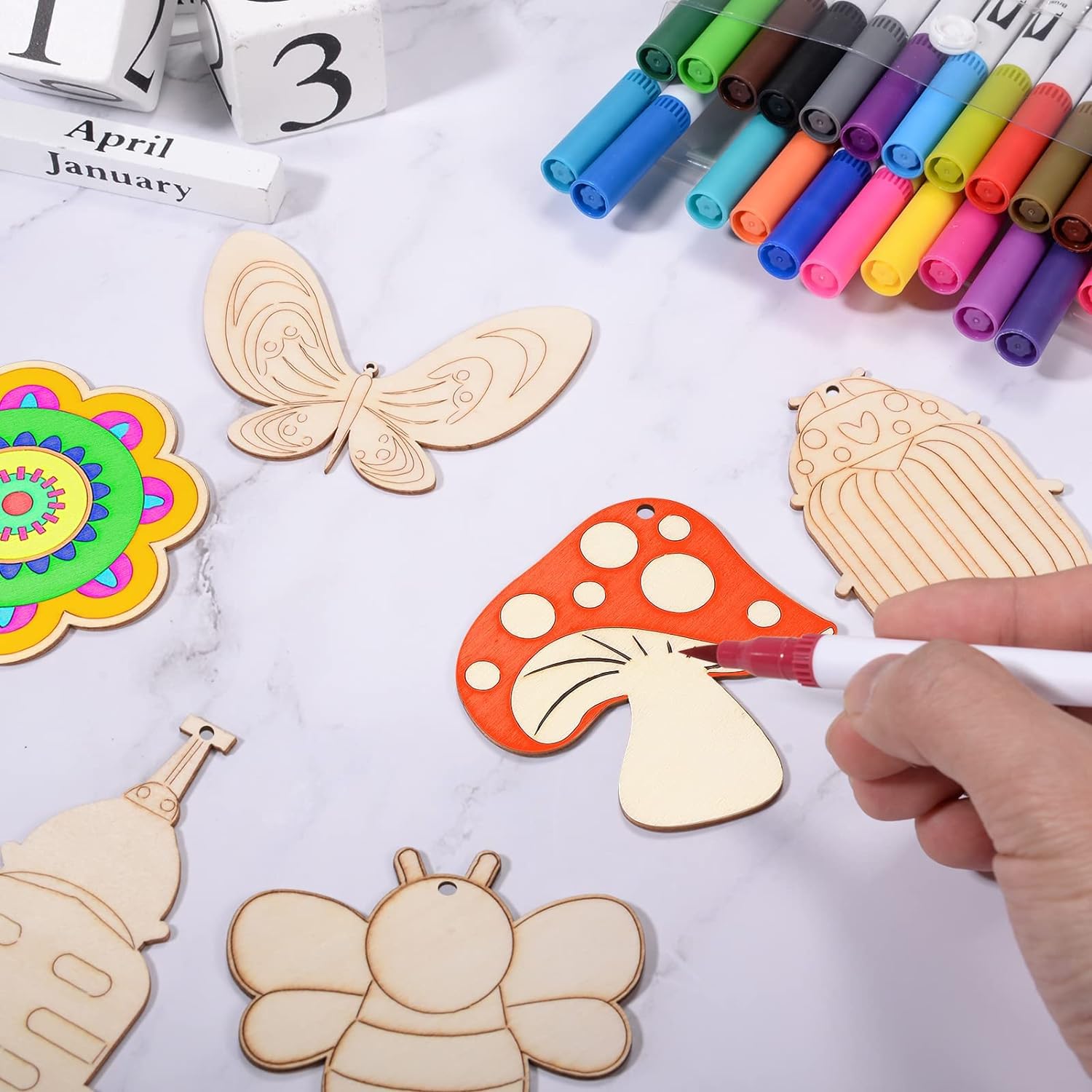 Wooden craft shapes with colorful markers on a table