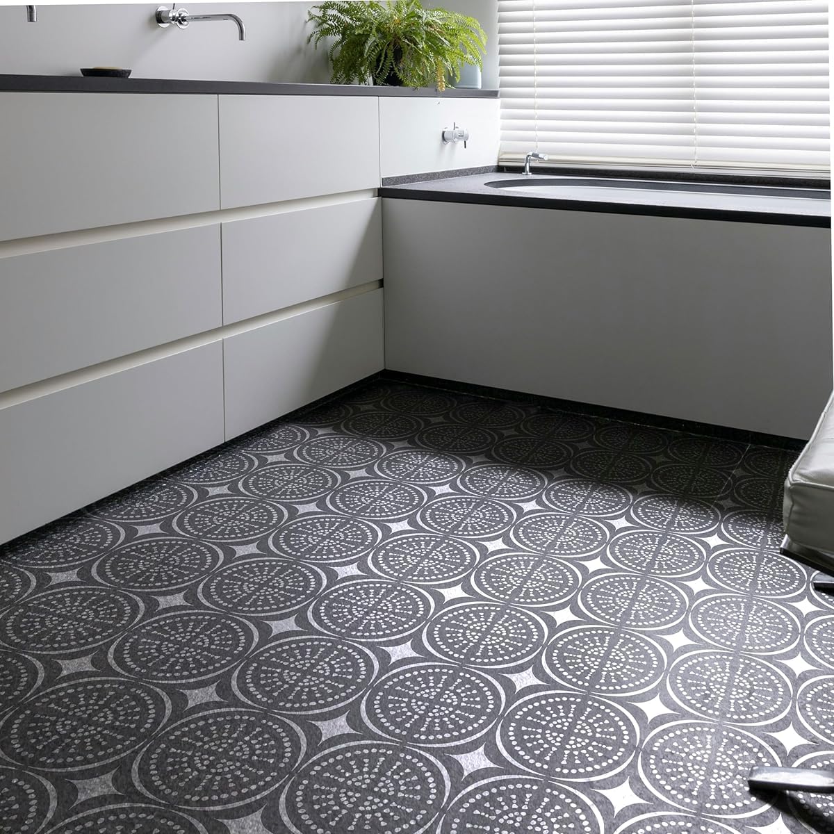 Modern kitchen with white cabinets and a patterned black and white floor.
