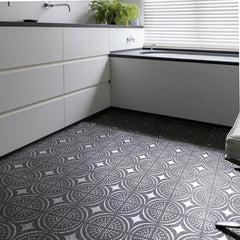 Modern kitchen with white cabinets and a patterned black and white floor.