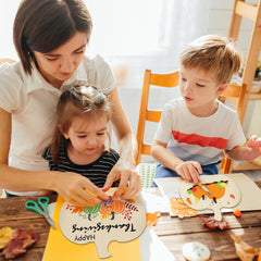 Woman and two children engaged in a craft activity at a table.