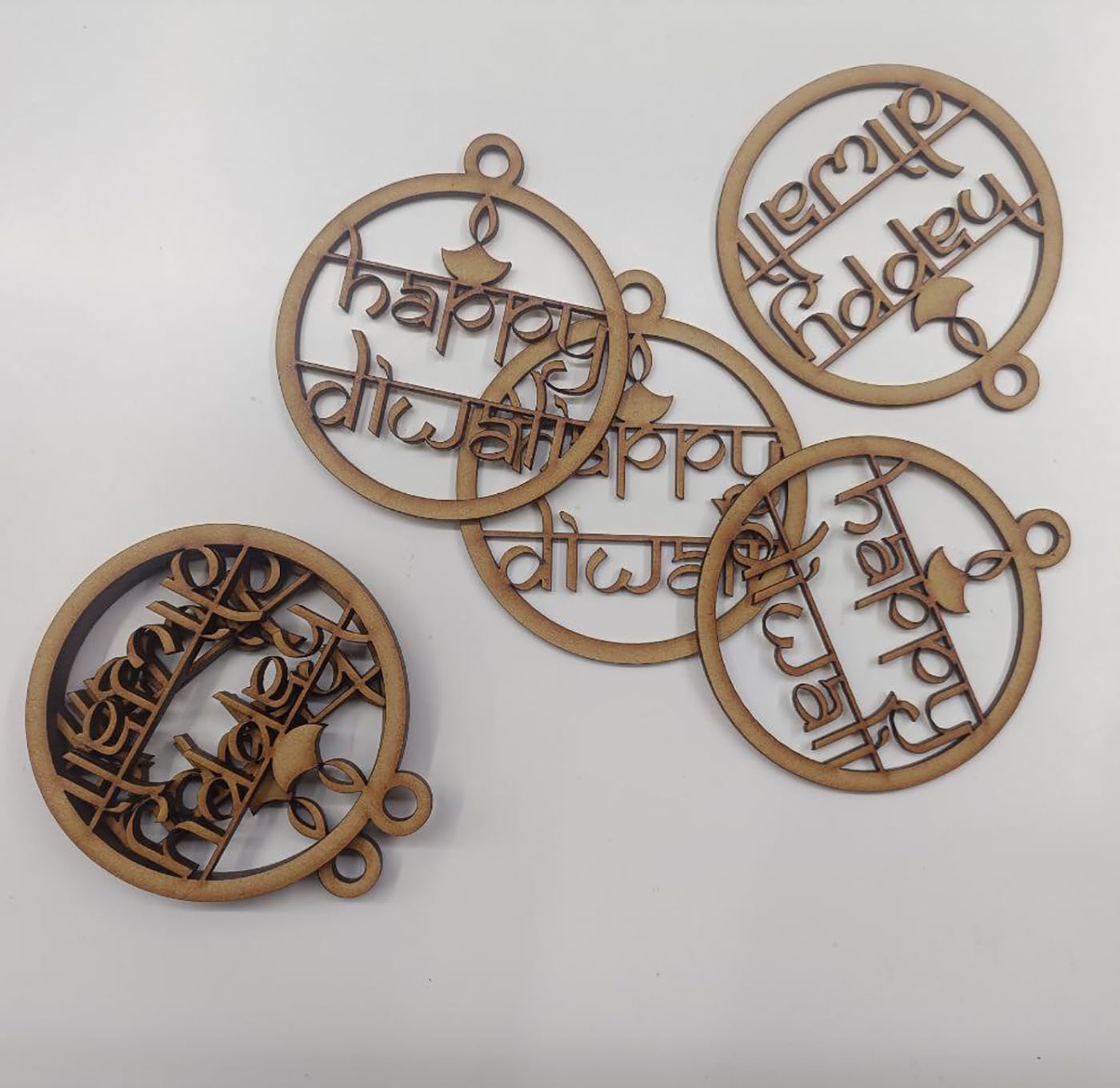 Decorative wooden pieces with 'Happy Diwali' text on a white background