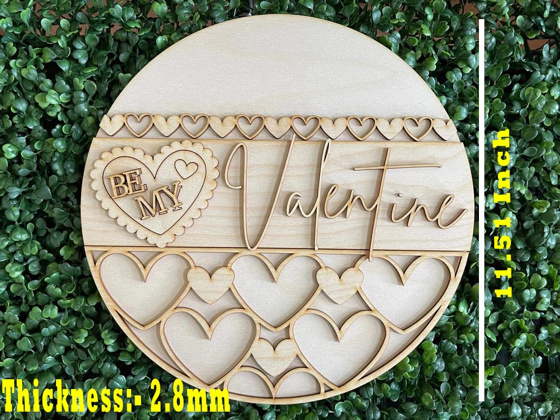 Wooden heart-shaped ornament with 'Be My Valentine' text on a green leaf background