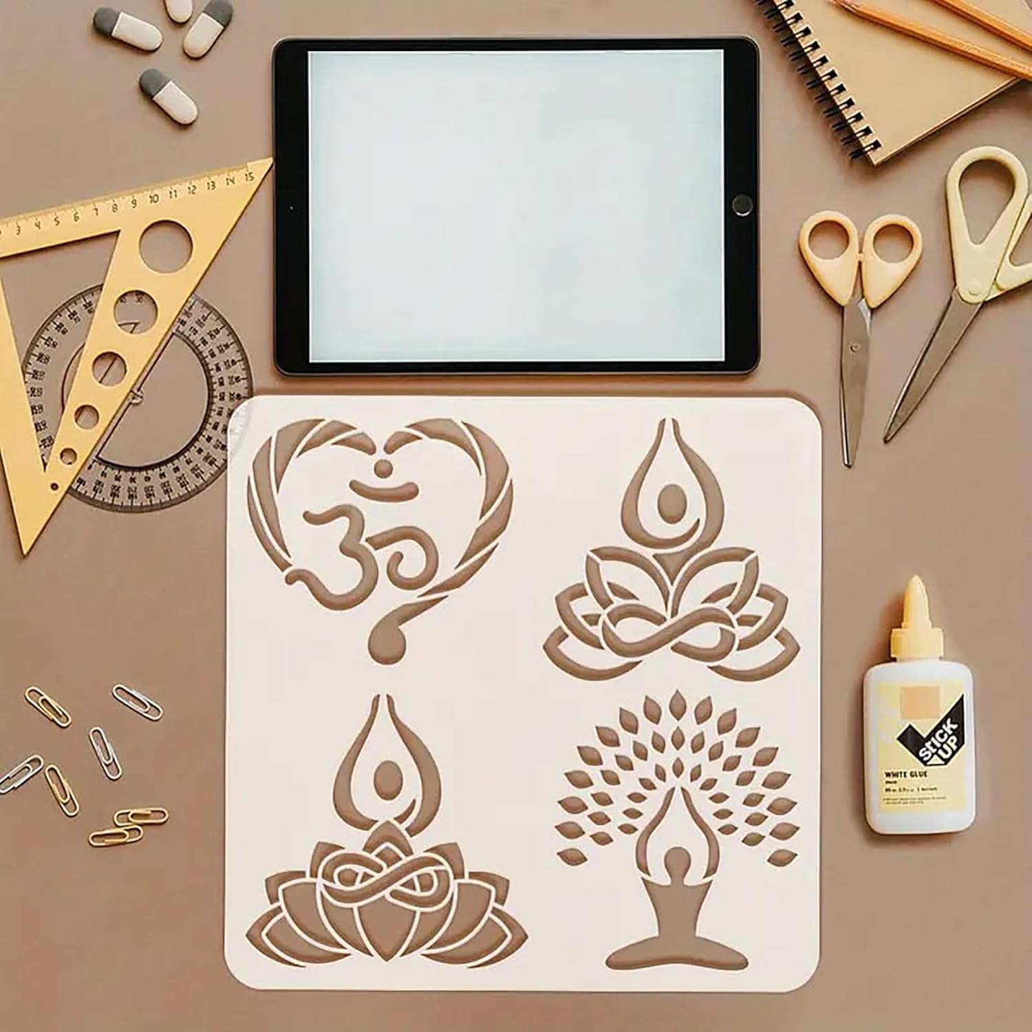 Stencils with yoga-themed designs on a brown surface with stationery items.