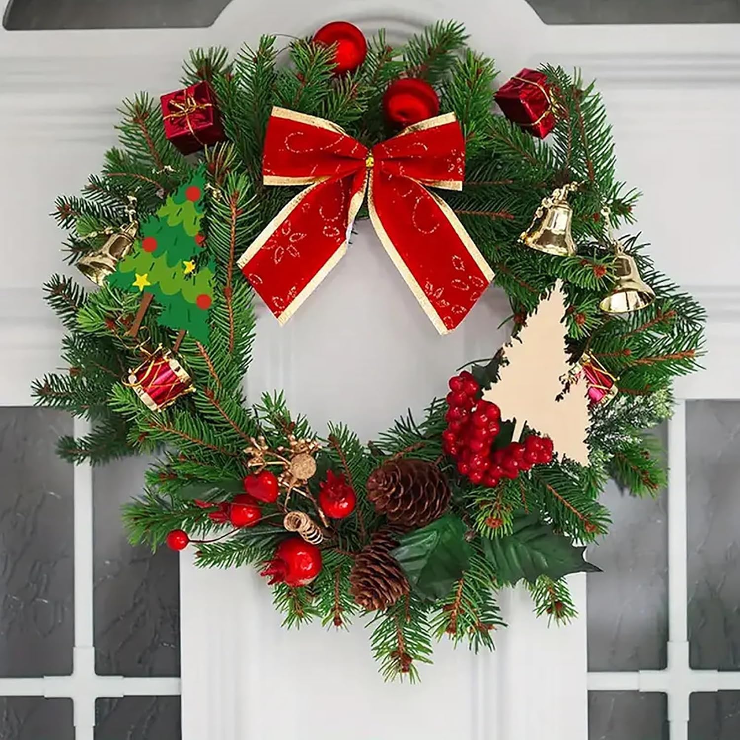 Decorative Christmas wreath with red bow, berries, and small gifts on a white door.