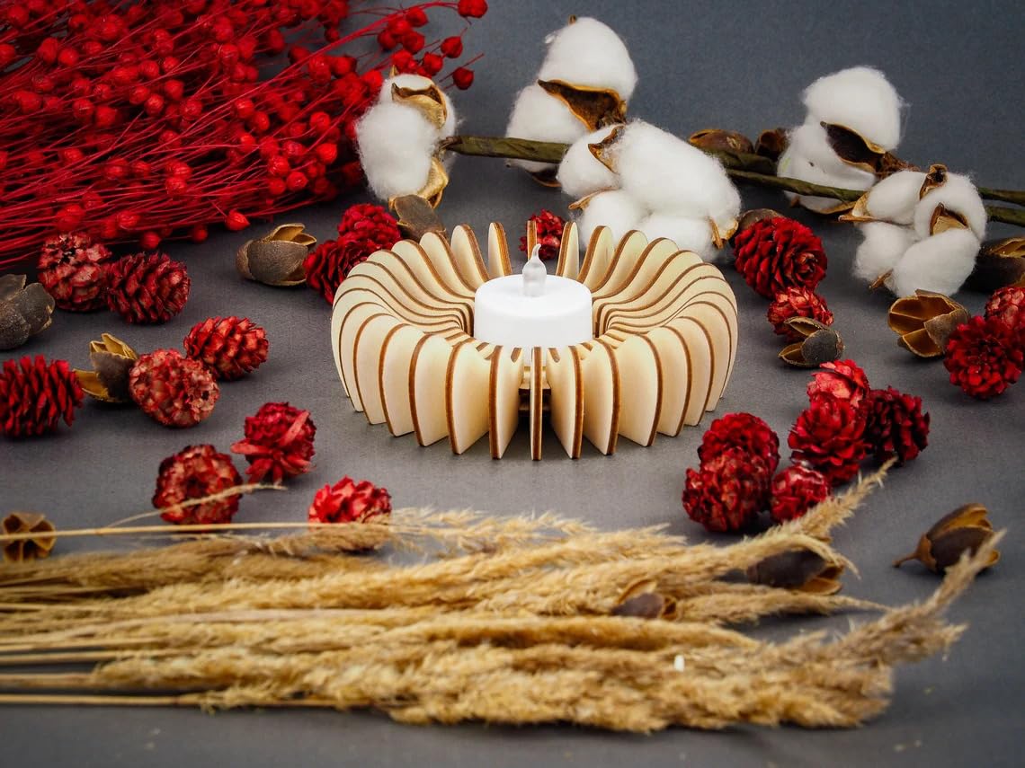 Decorative candle holder with cotton, red berries, and dried plants on a gray background