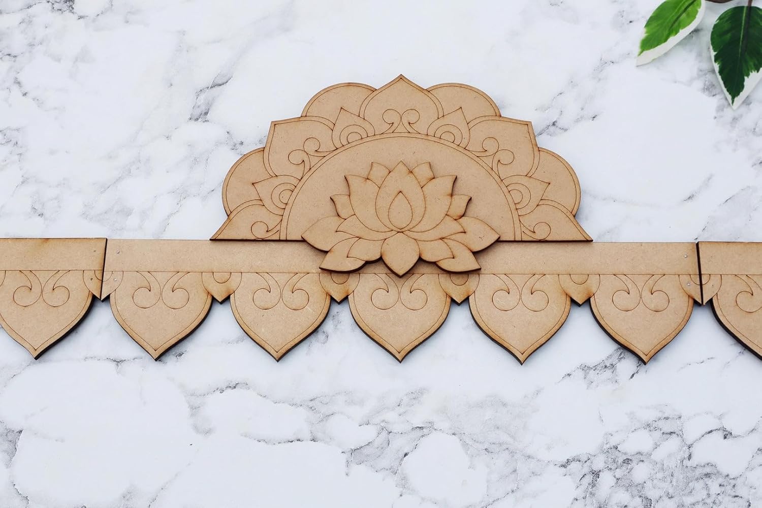 Wooden decorative panel with lotus flower design on a marble surface