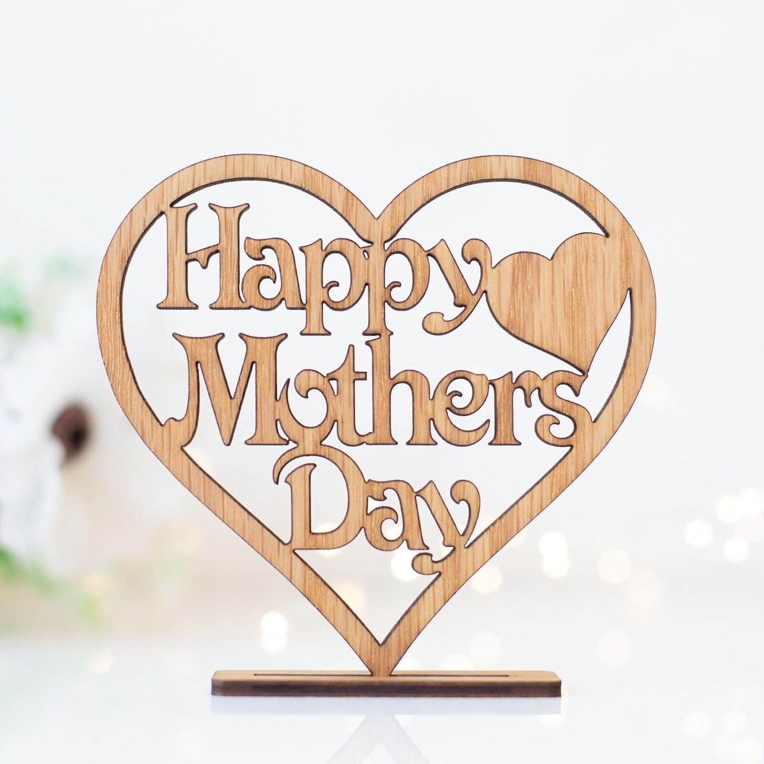 Wooden heart-shaped sign with 'Happy Mothers Day' text on a white background
