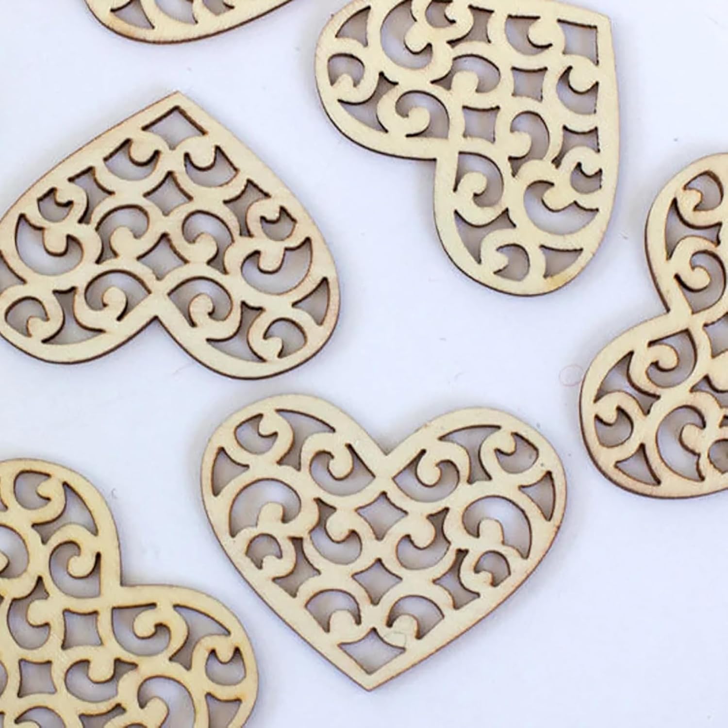 Decorative wooden hearts with intricate cut-out patterns on a white background