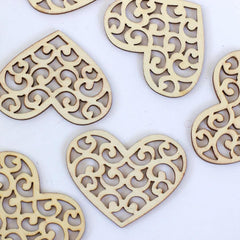Decorative wooden hearts with intricate cut-out patterns on a white background