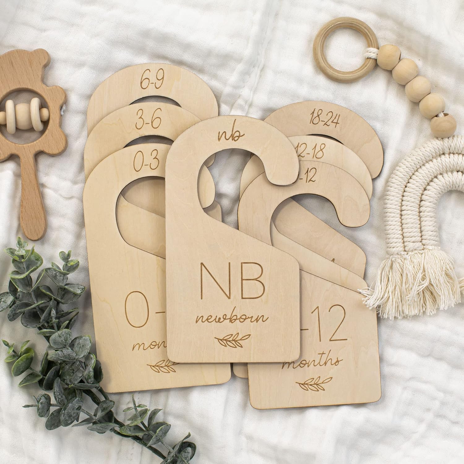 Wooden baby milestone markers with decorative elements on a textured surface